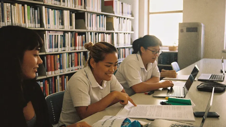 Mahasiswa belajar bareng di perpustakaan kampus sambil membahas materi yang sudah di-highlight